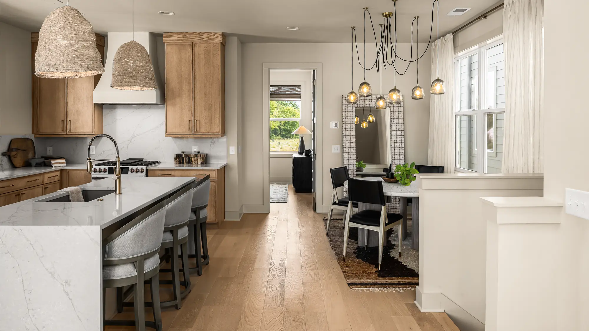 solaya-homes-02-kitchen-dining Kitchen island and dining area with oak floors in a home at Solaya at the Lanes