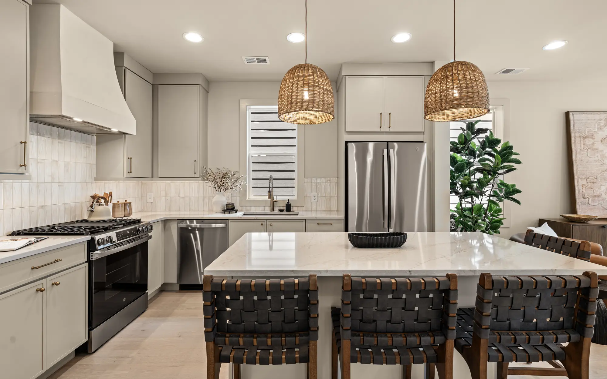 solaya-homes-06-kitchen Kitchen with island seating and woven pendant lights in a home at Solaya at the Lanes
